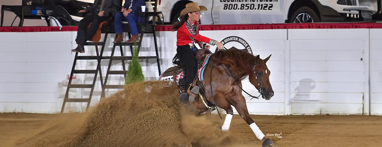 Peyton Derr, performing sliding stop on chestnut reining horse