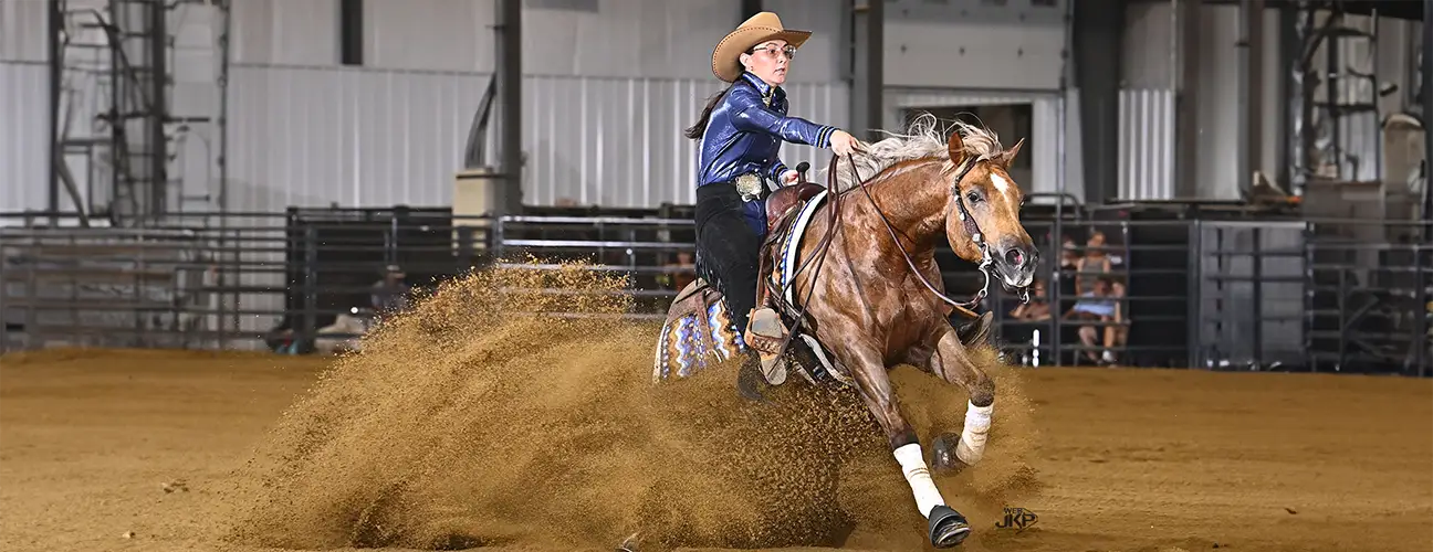 Peyton Derr, performing sliding stop on chestnut reining horse
